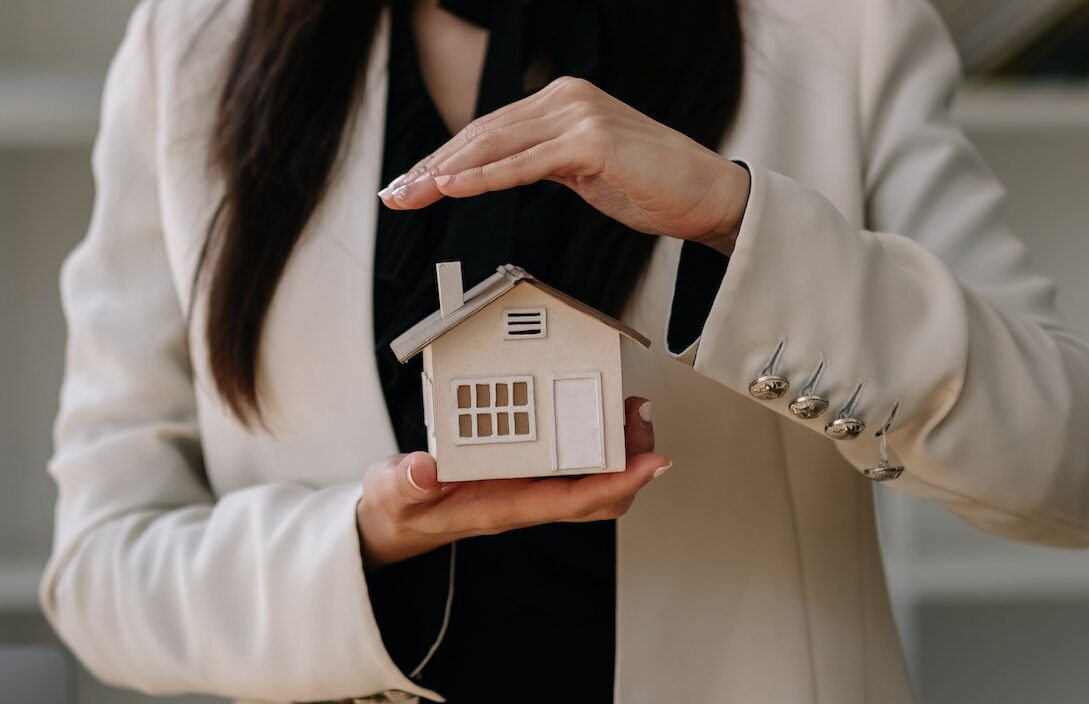 House covered of woman hands - insurance real estate concept.